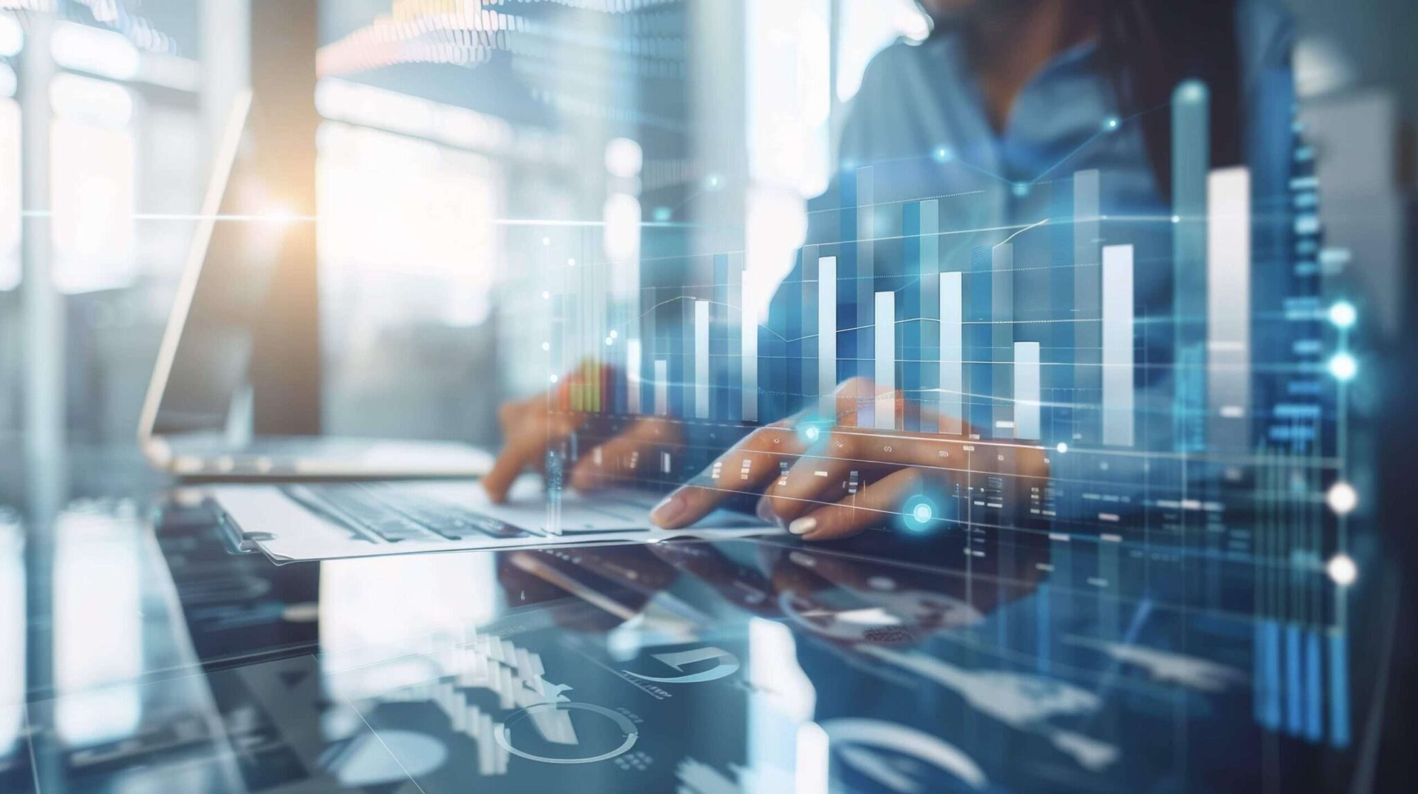 A close-up of hands typing on a laptop overlaid with financial and analytics charts